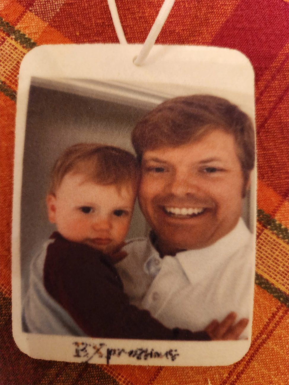 A man smiling with a baby in his arms.