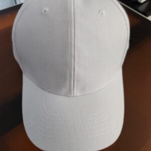 A plain white baseball cap on a dark surface.