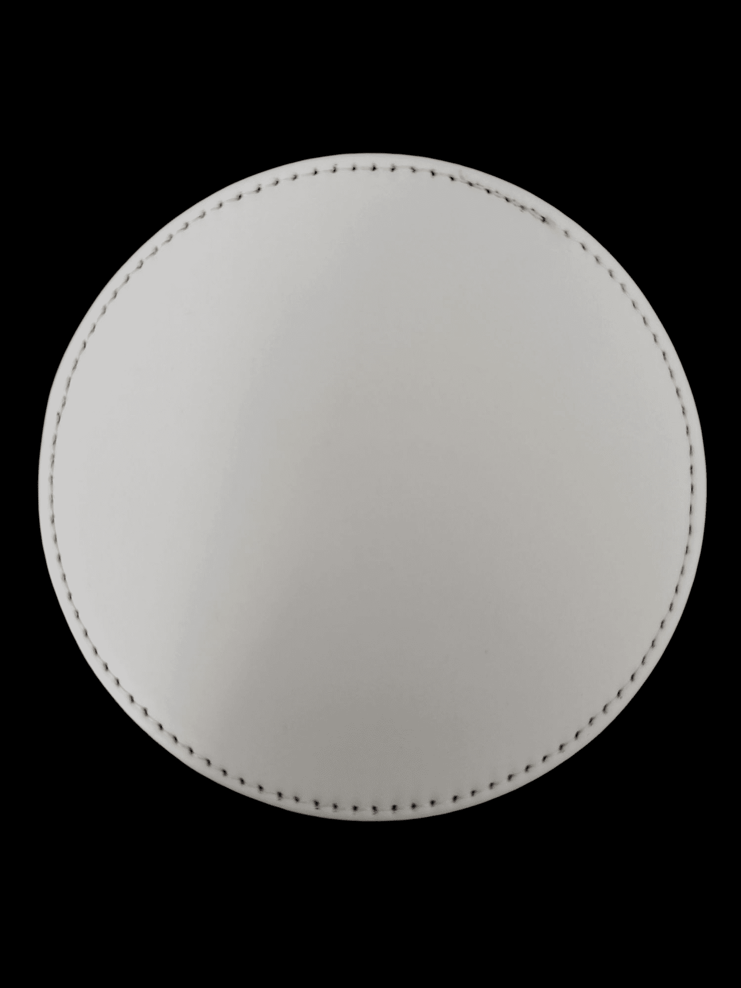 Top-down view of a circular, textured white object with stitching around the edges.