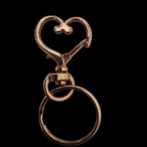 Copper-colored heart-shaped keychain with a circular ring on black background.