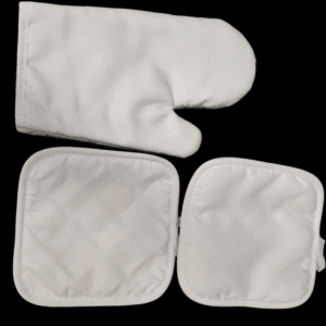White quilted oven mitt and two matching pot holders on black background.