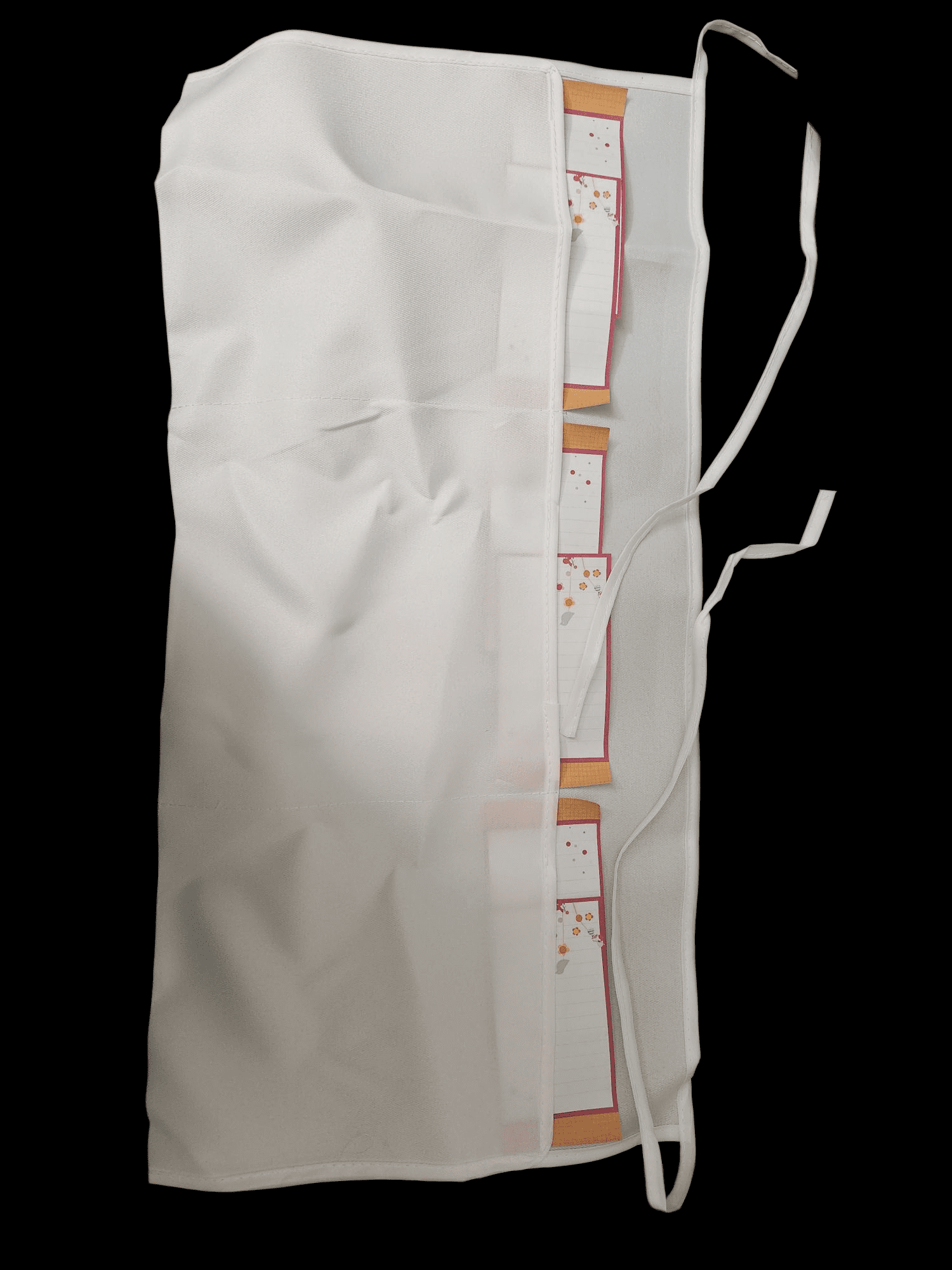 A white fabric piece with attached brown and white labels on a black background.