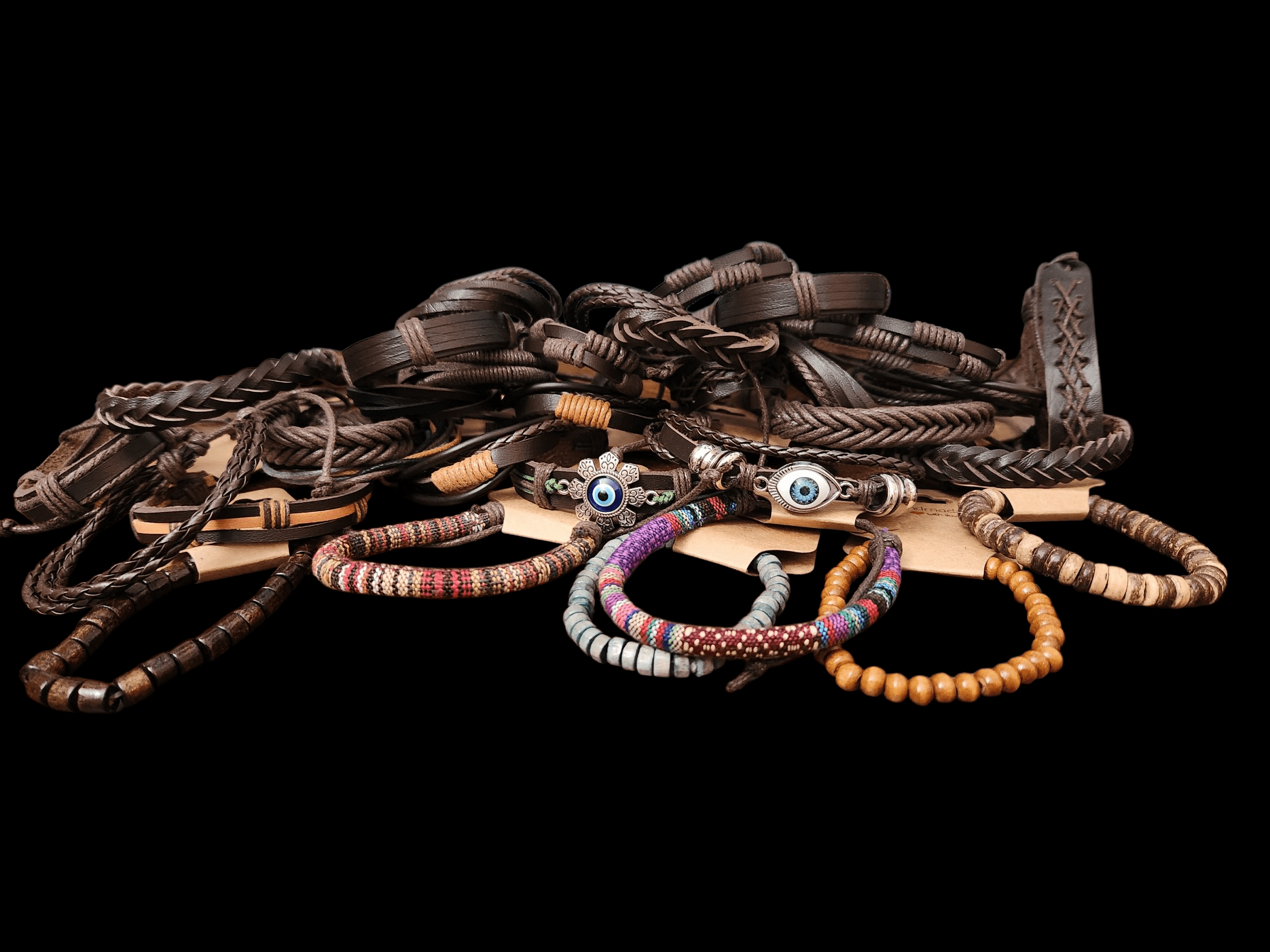 A variety of handcrafted bracelets and necklaces displayed on a black surface.