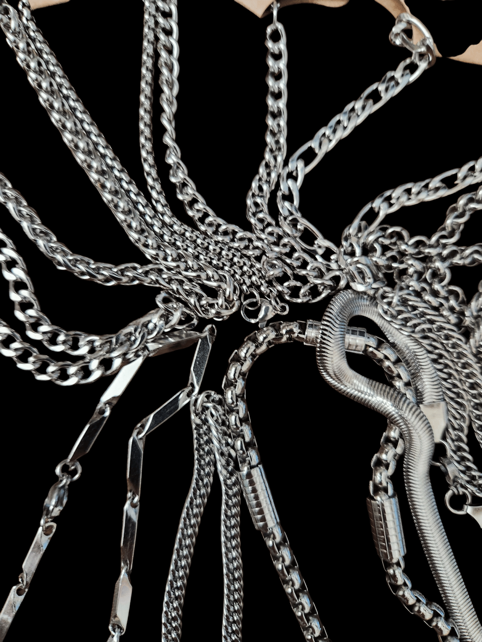 Close-up of silver chains tangled on a black background.