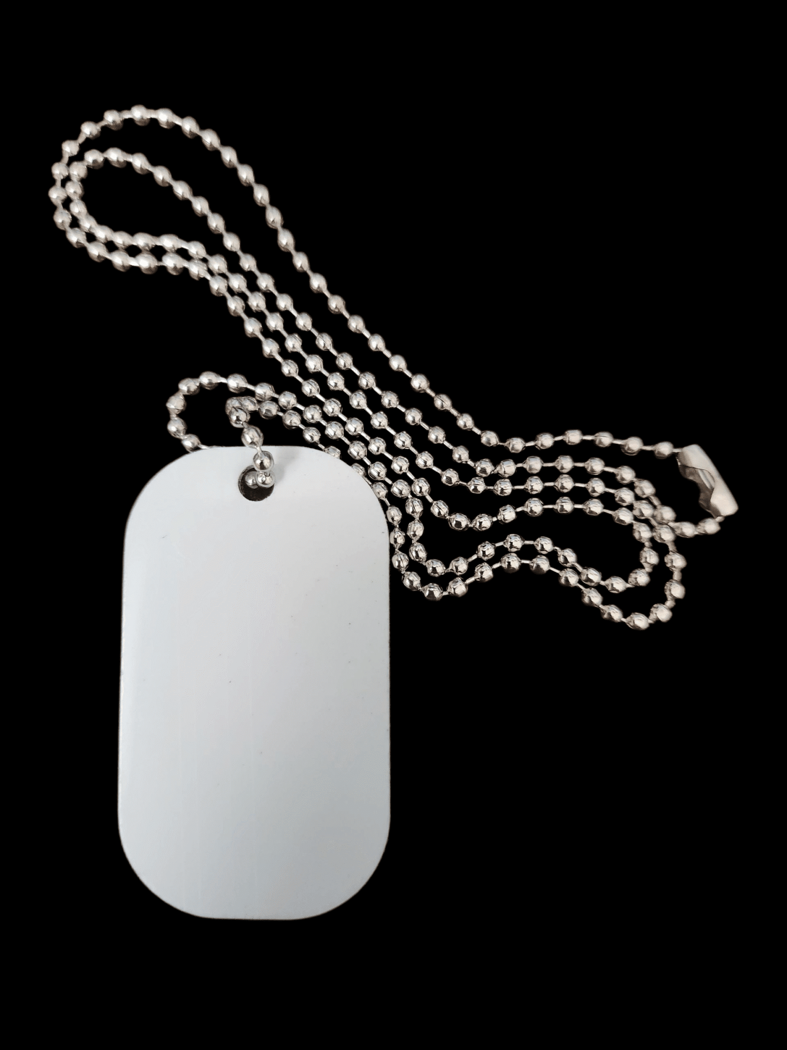 A blank dog tag on a silver ball chain against black.
