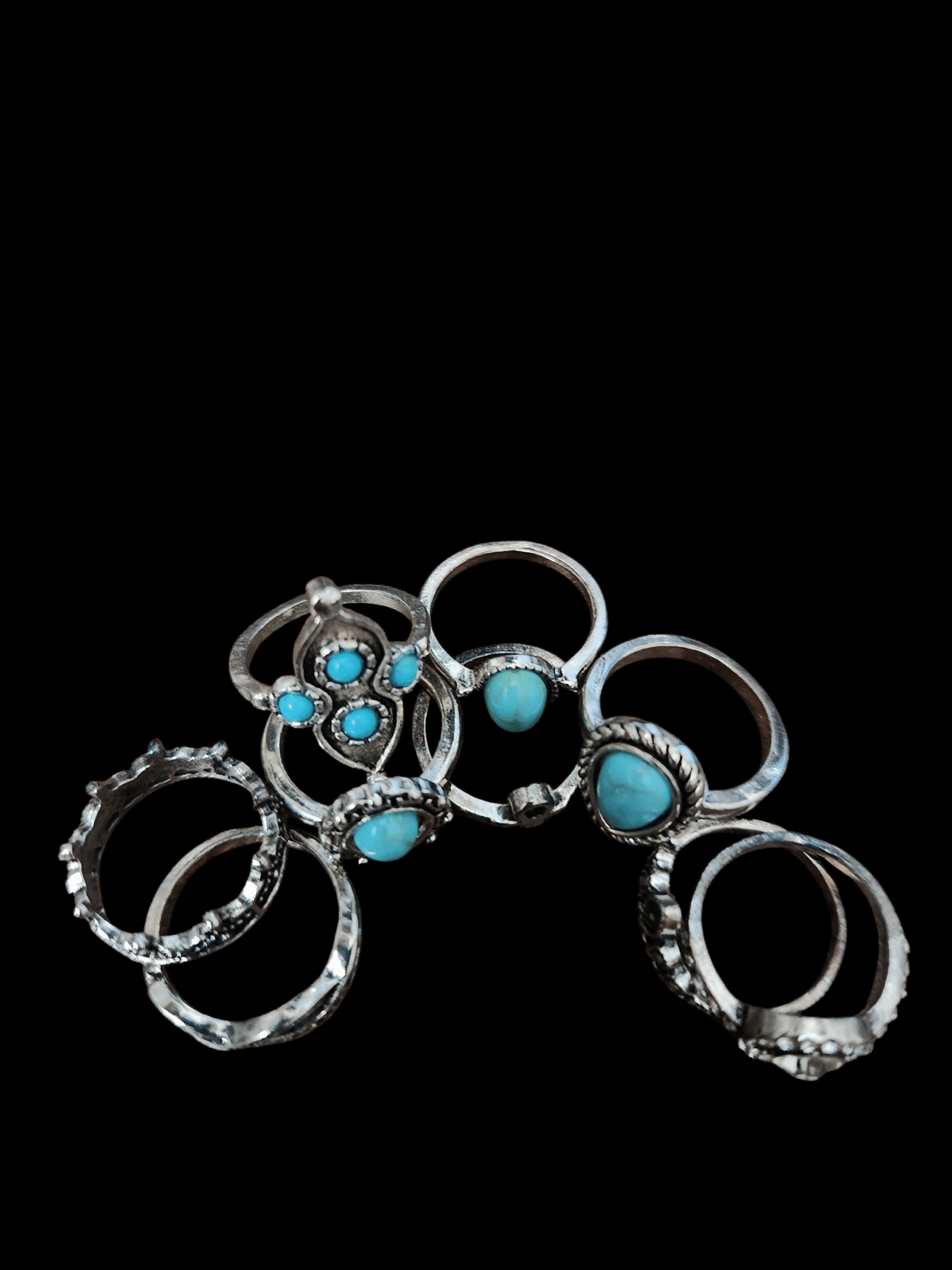 A collection of silver rings with turquoise stones and intricate designs.
