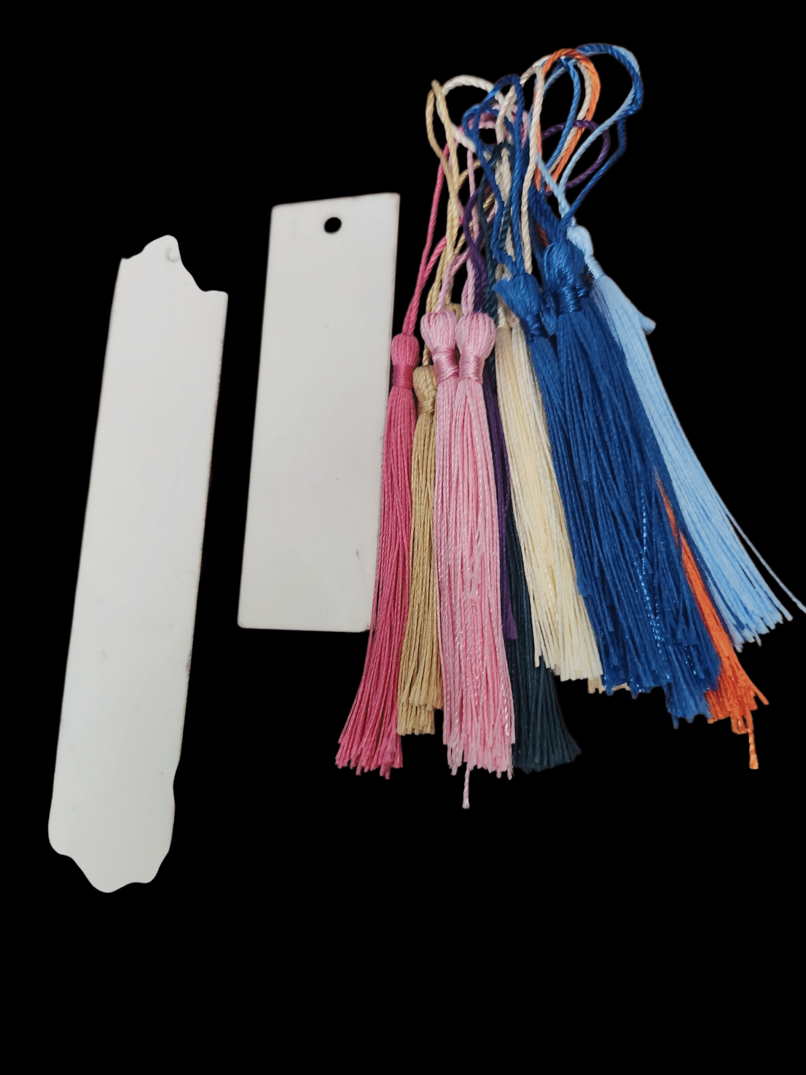 Various colorful tassels and blank tags on a black background.