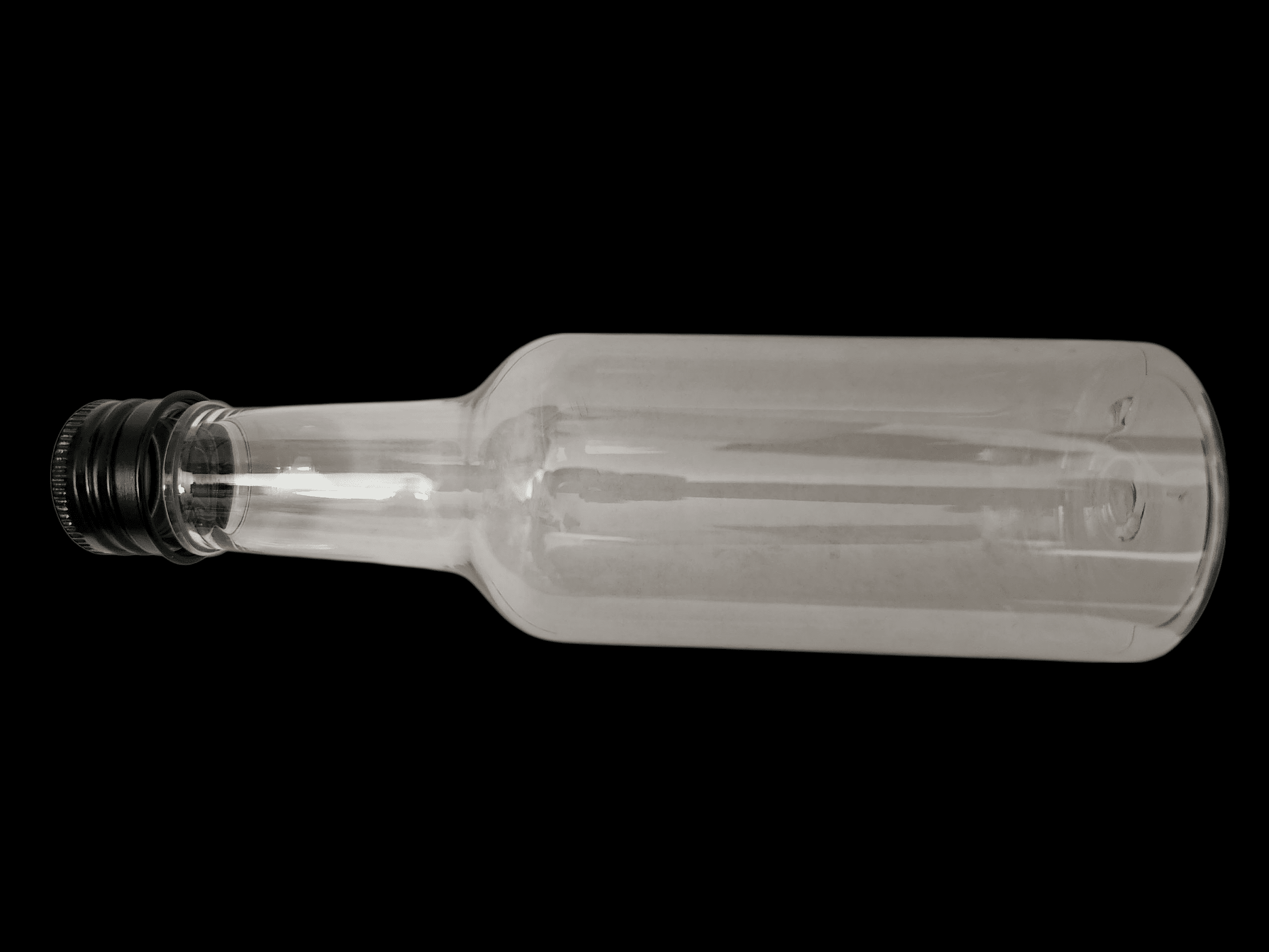 Clear, empty glass bottle with a black background.
