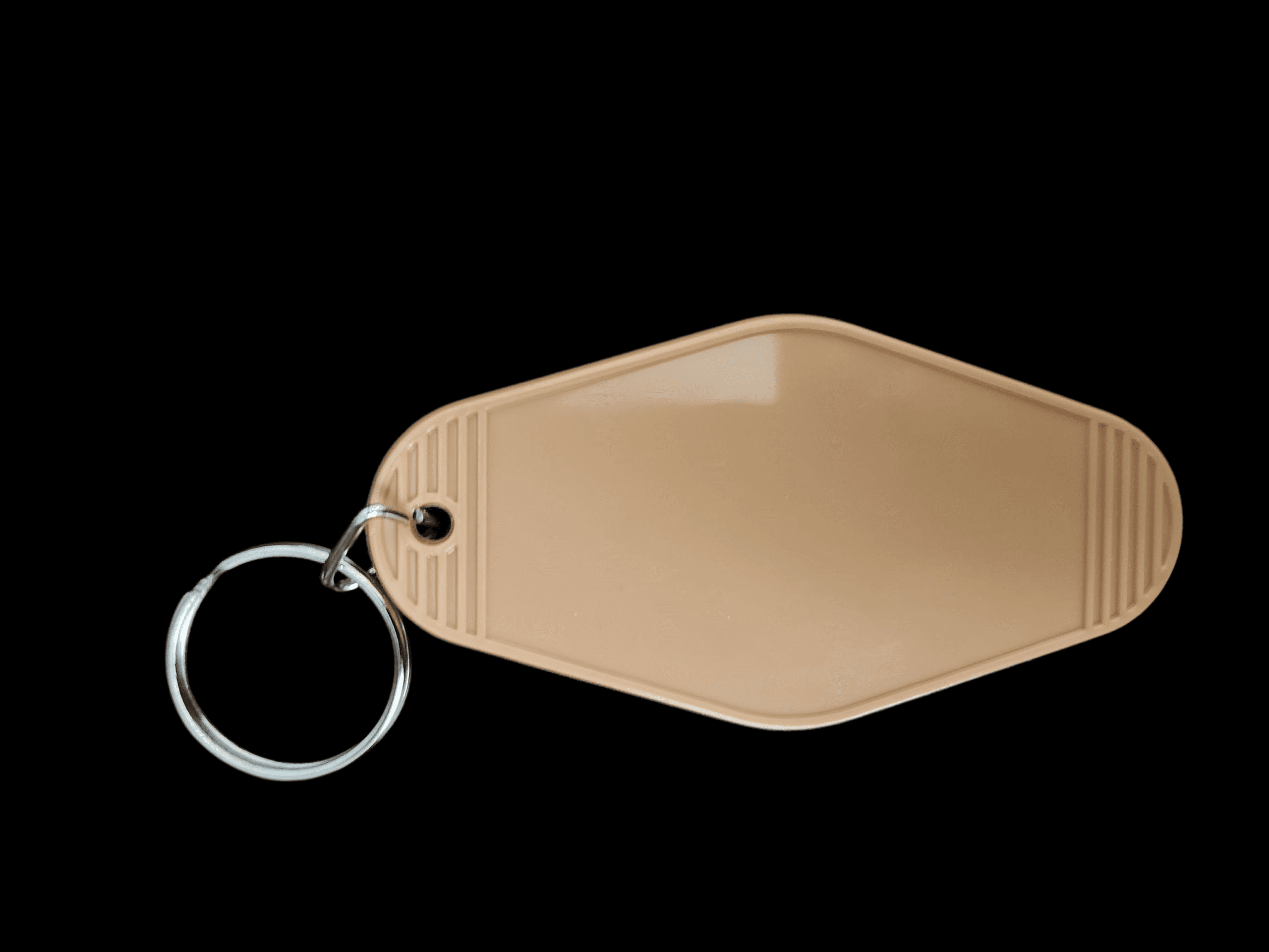 Beige leather keychain with silver ring on black background.