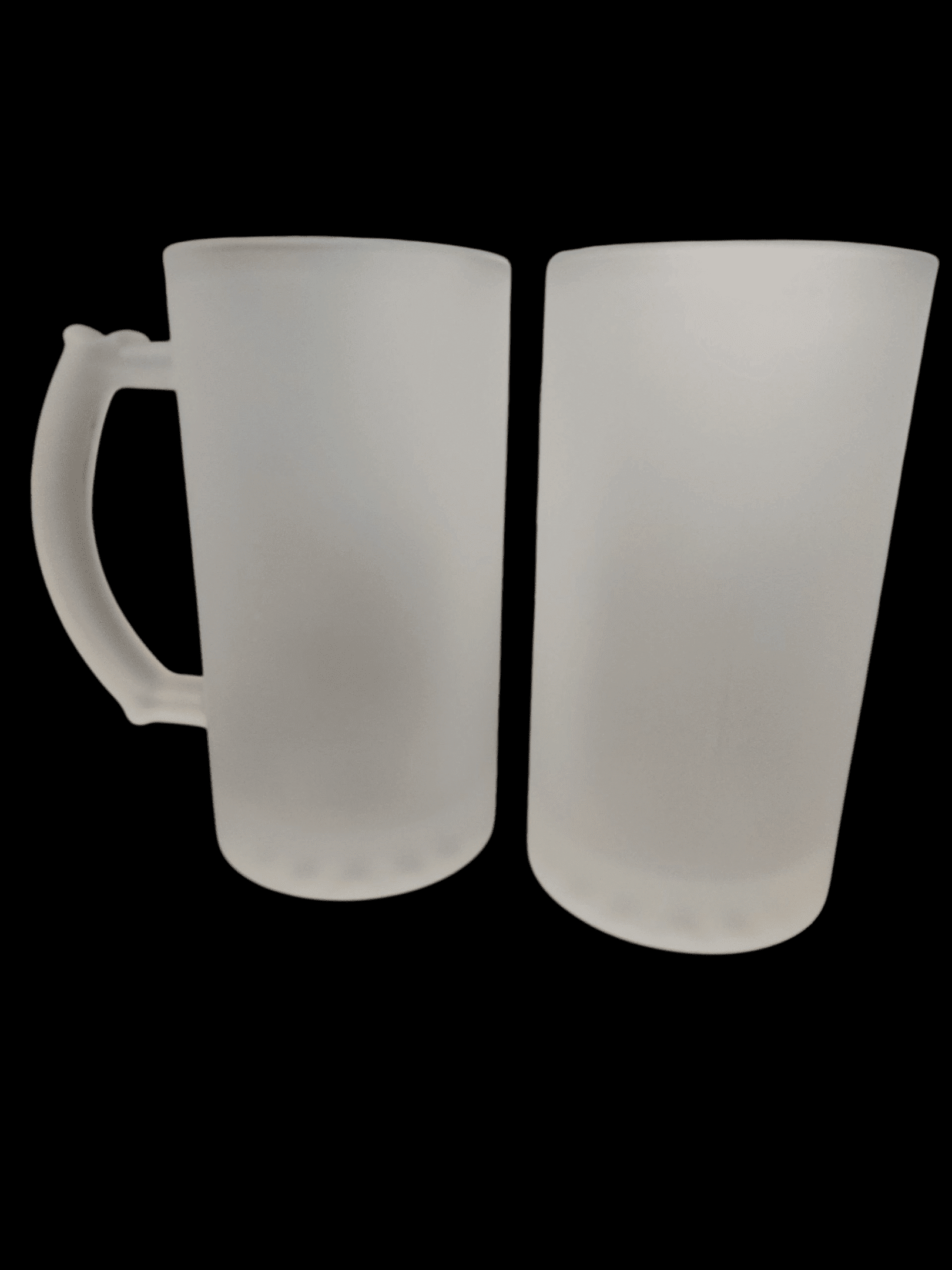 Two empty frosted glass mugs on a black surface.