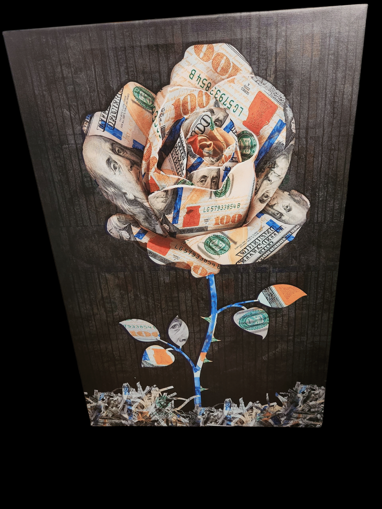 A rose crafted from newspaper with colorful paper leaves on a dark background.