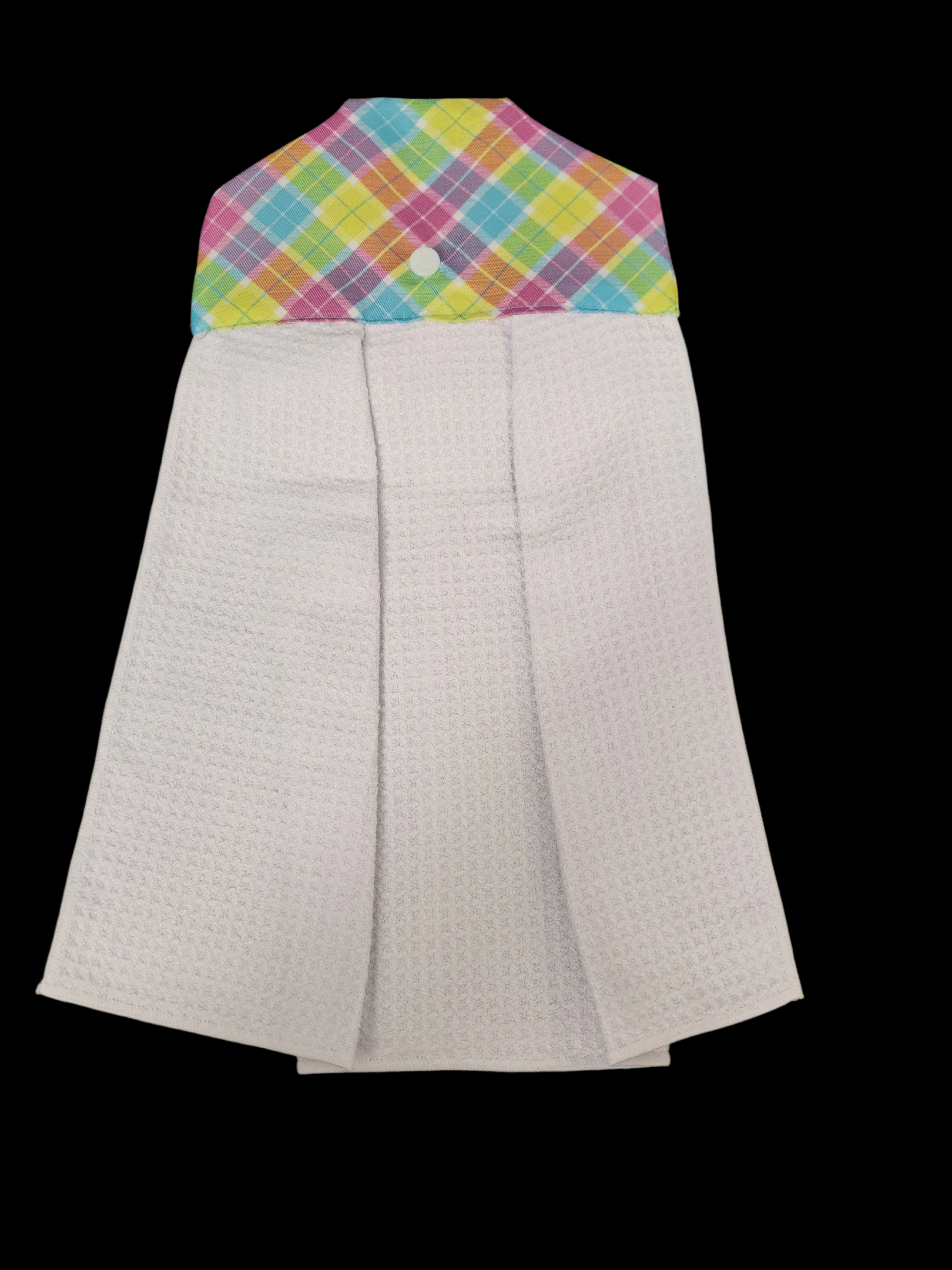 A white kitchen towel with a colorful checkered top hanging.