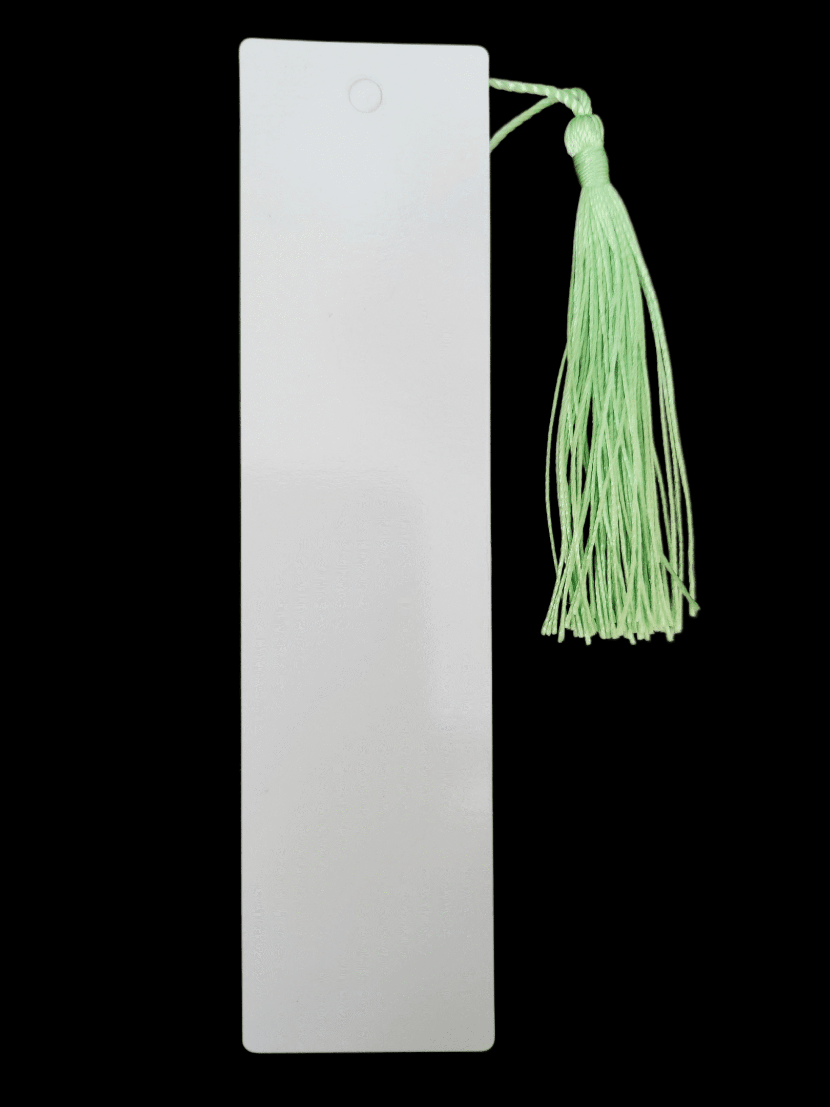 A white bookmark with a green tassel on a black background.