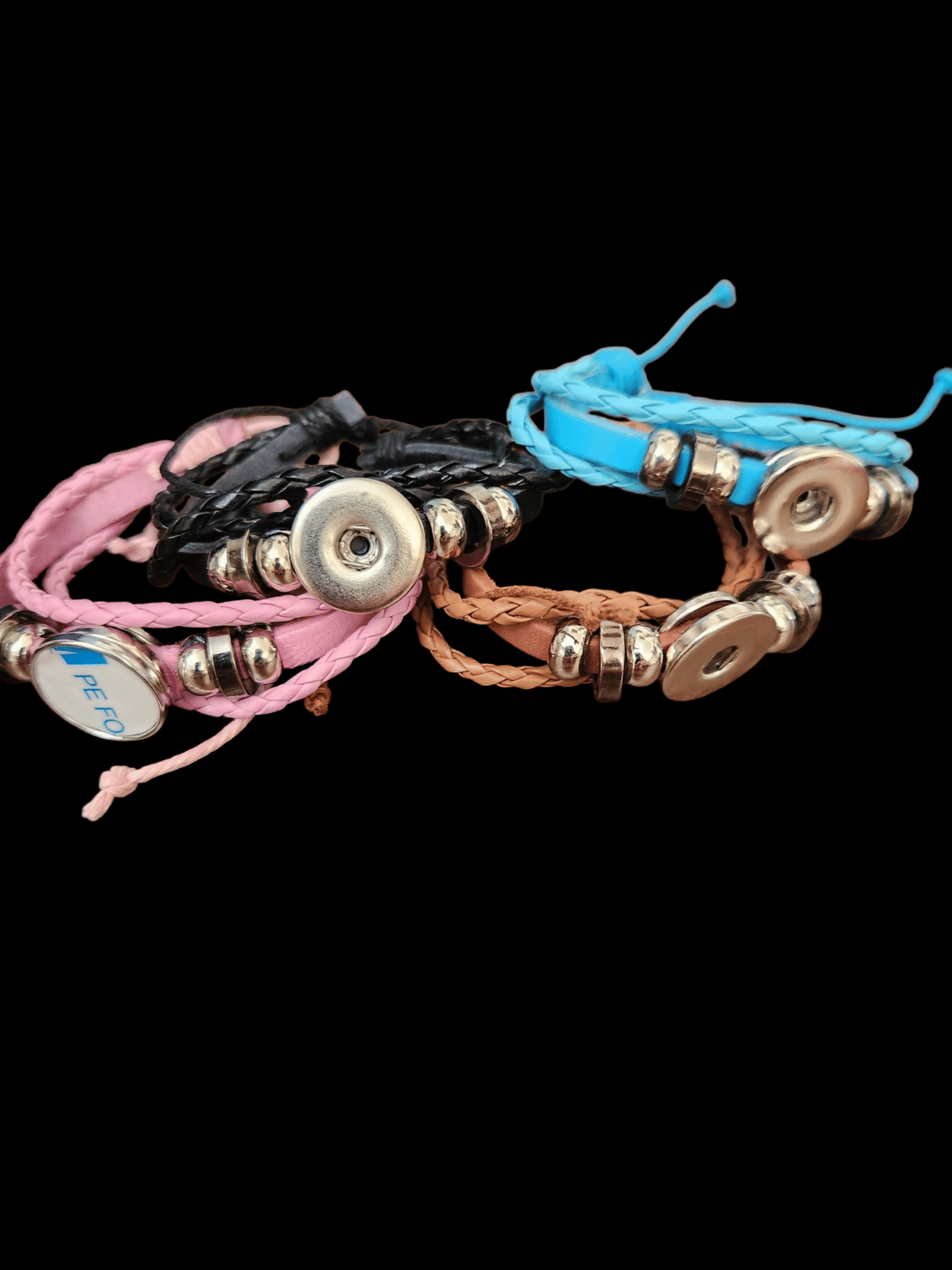 Three colorful leather and bead bracelets arranged on a black background.
