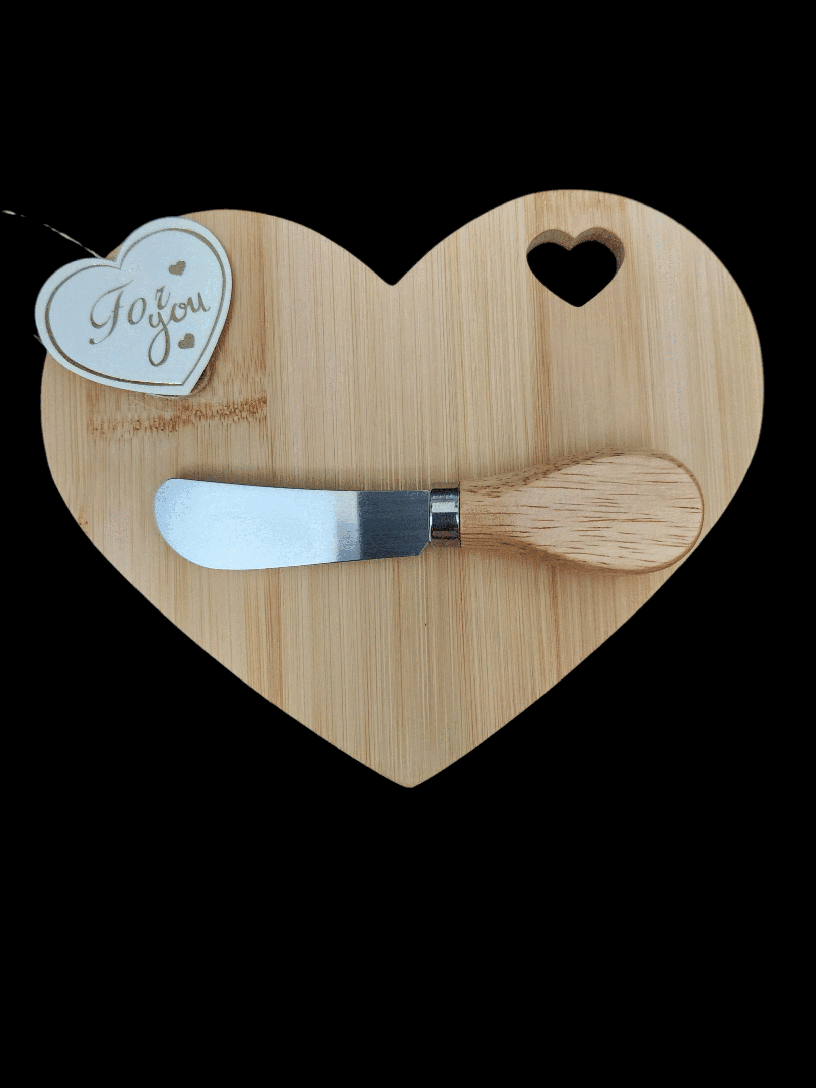 Heart-shaped wooden board with a cheese spreader and a 'Joy!' tag.