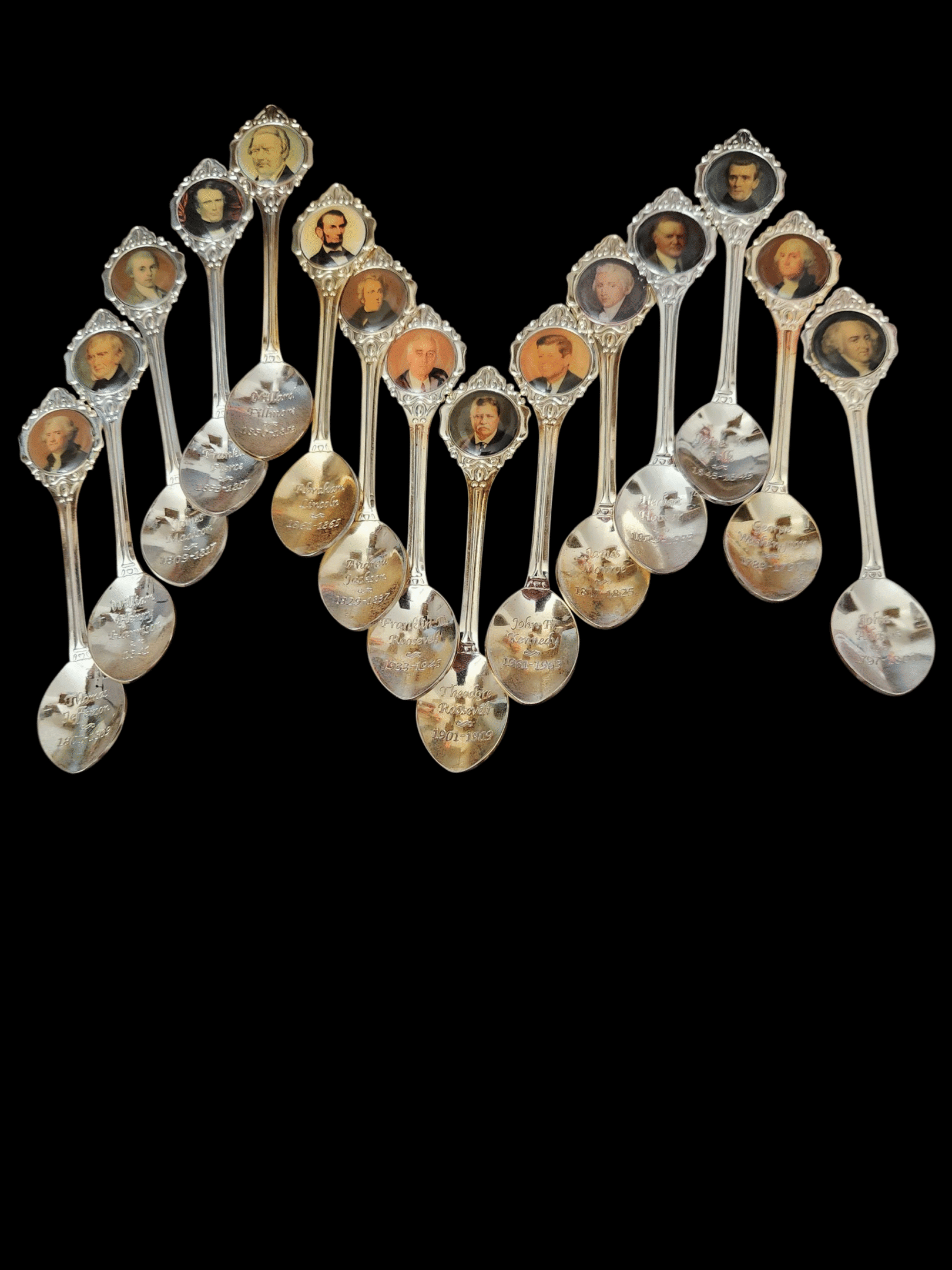 Spoons filled with various spices arranged in a zigzag pattern on a black background.