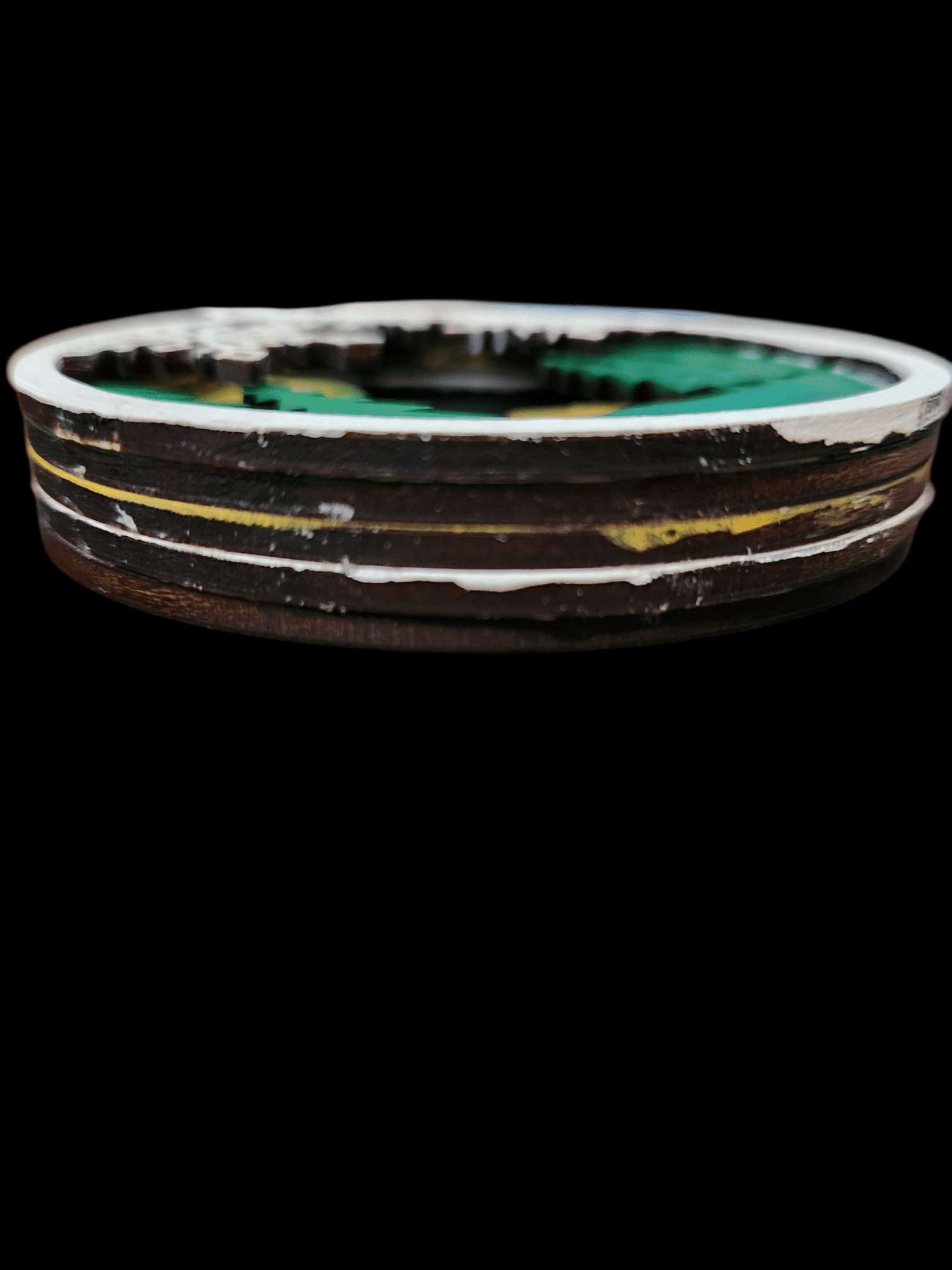 A round, multi-layered cake with white, brown, and green layers.