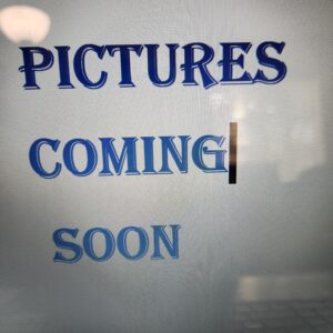 Sign reading 'Pictures Coming Soon' with a tape mark.